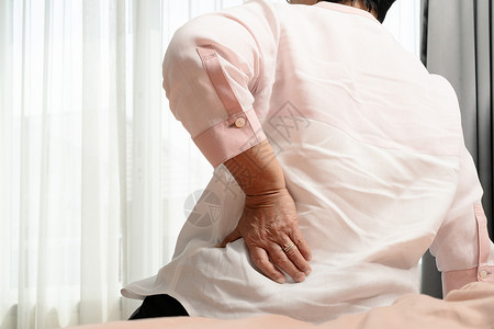 老年妇女在家背痛健康问题概念沙发在室内脊柱图片