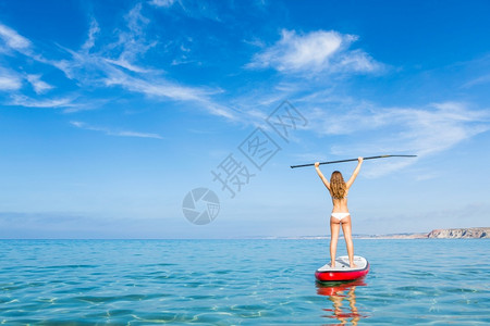 美丽的成功假期一个美丽和快乐的女人举起手来学球桨图片