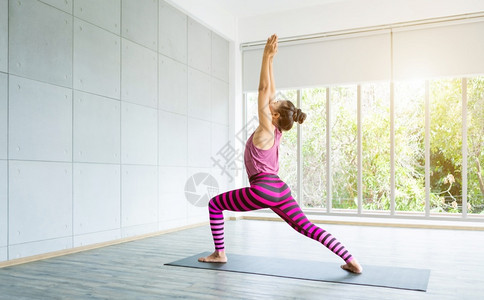 居家瑜伽锻炼的年轻女子图片