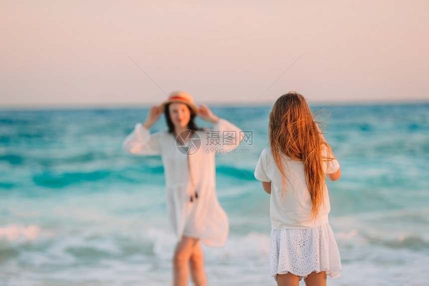 闲暇相机可爱的小女孩在热带海滩给妈拍照小可爱在热带海滩给妈拍照图片