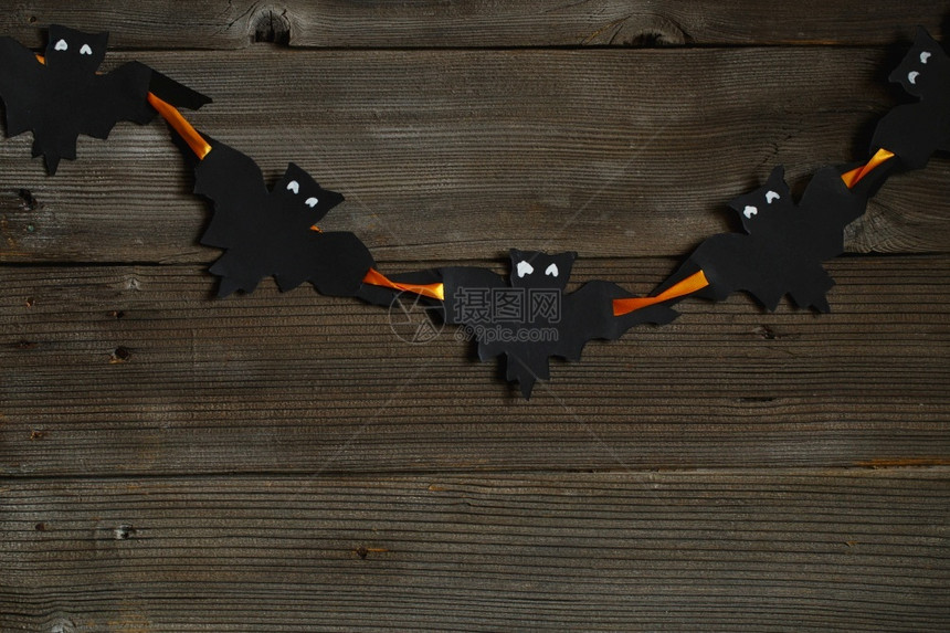 十月象征黑纸蝙蝠用旧木制背景设计万圣节复制空间万圣节背景用黑色纸板做成的圆形蝙蝠在明亮的橙色丝带上季节图片