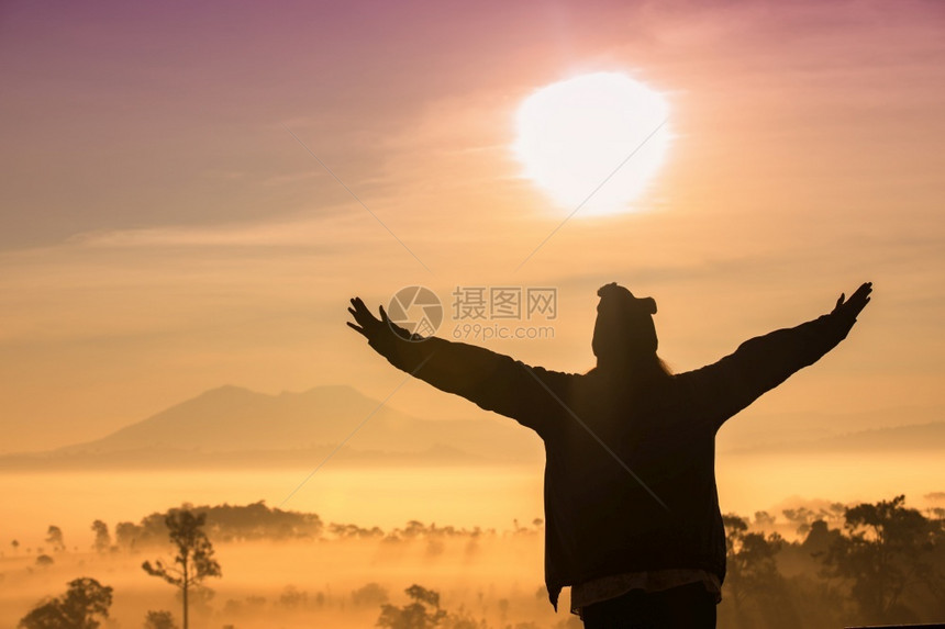 自由旅行者女神的休光月她们带着举起的手站享受美丽的大自然在日落和雾时欢呼青年游客多雾路段景观图片