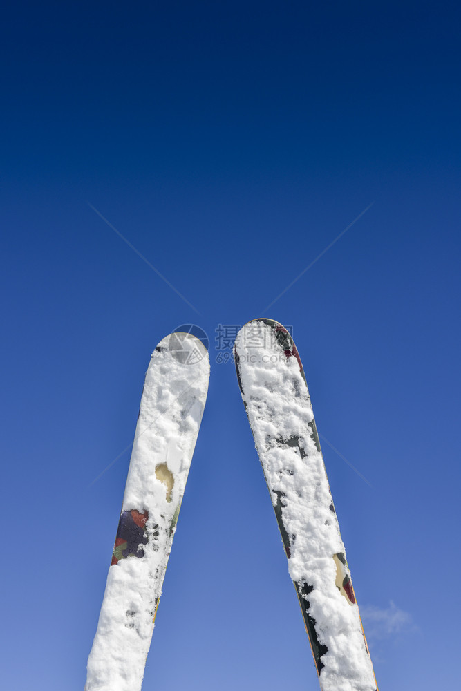 缆车一个滑雪者穿戴的对等滑雪板背着山上脉景是一对在把椅子起坐时向下看手脚的滑雪机捕获鞋背上是一对山地散景蓝色的图片