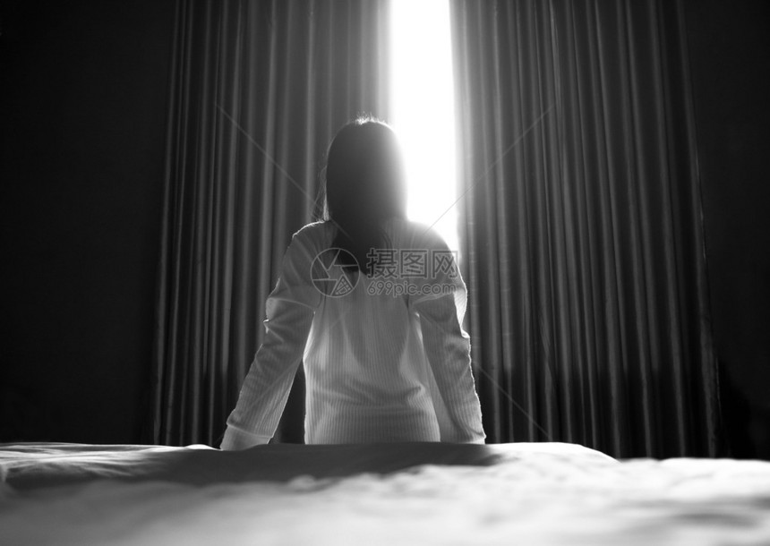 天卧室睡房保健概念的明亮清晨坐在一个着和拉懒惰的亚洲妇女后座困图片
