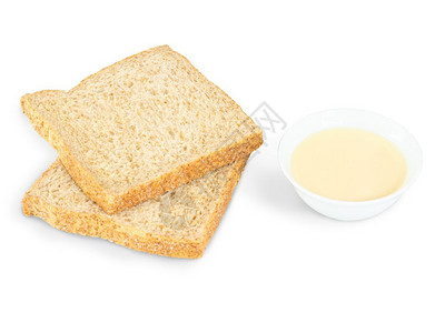 早餐法语白底碗里加糖的浓缩牛奶和紧闭面包粉图片