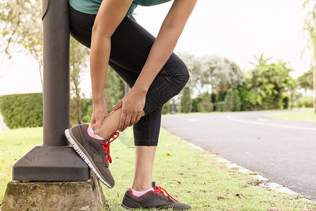 年轻的健身女运动员在脚踝腿上感到疼痛户外锻炼活动概念女士扭伤图片