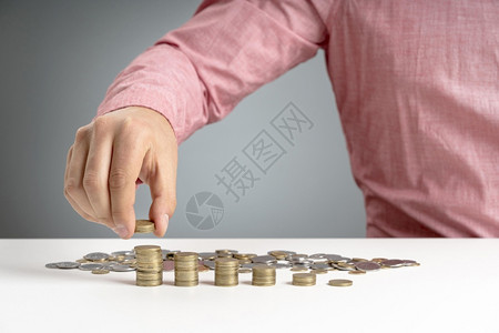 美丽的摄影人堆叠硬币的桌台投资手税图片