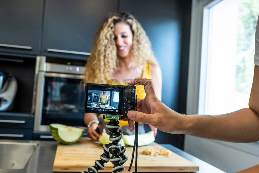 过程三脚架女人在厨房里用相机录制像瓜刀一样的镜头幸福图片