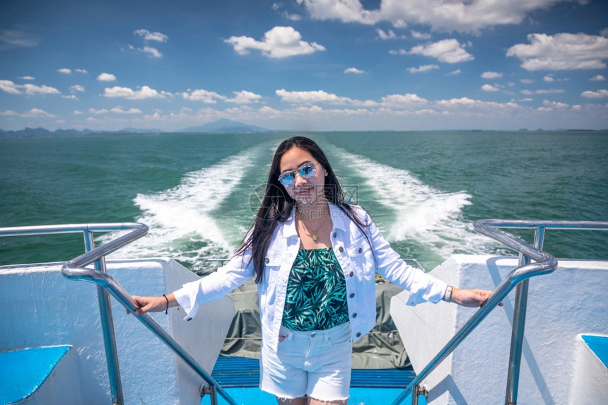 太阳镜亚洲人在泰国克拉比的一艘快艇上亚洲女孩图片
