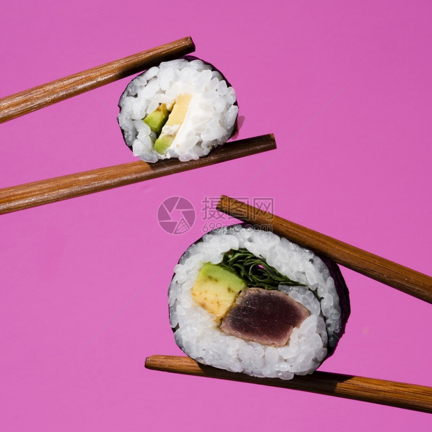 由筷子持有的奥利普斯数字摄影机寿司卷手蔬菜白色的图片