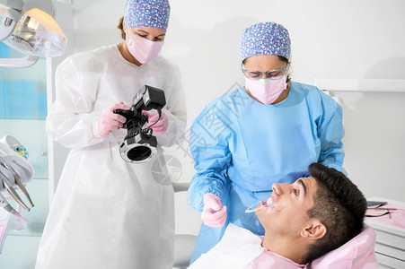 给病人拍照治疗的牙医形象图片