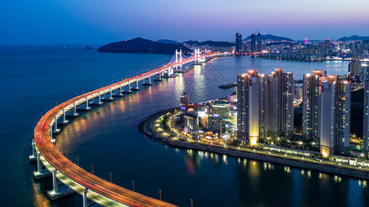 发光的建筑学交通位于韩国釜山的光建大中桥或万安天线和摩大楼建筑在南韩釜山夜照亮背景