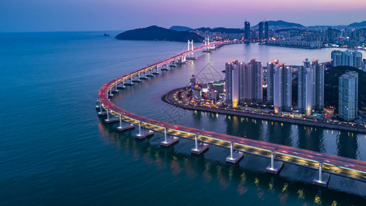 海亚洲人位于韩国釜山的光建大中桥或万安天线和摩大楼建筑在南韩釜山夜照亮运输背景