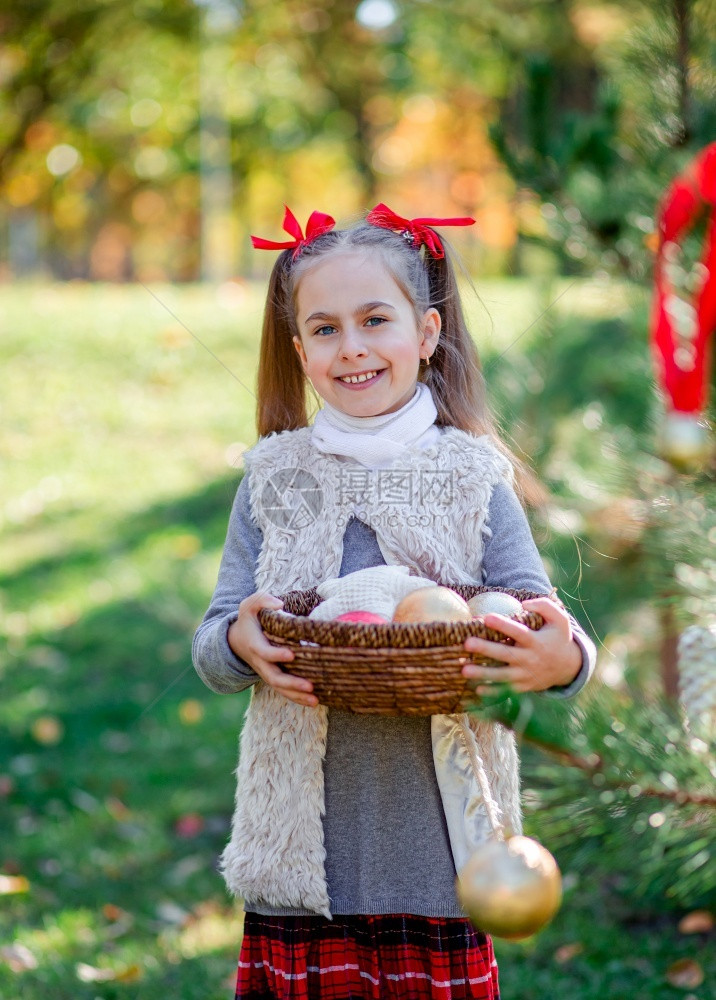 裙子手里拿着篮的圣诞装饰品女孩圣诞快乐节日女孩手里拿着篮子的圣诞装饰品假期女儿图片