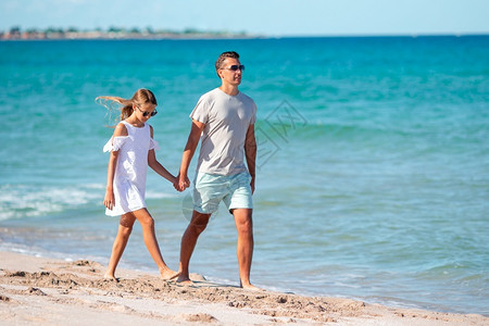 小女孩和父亲在海滩度假图片