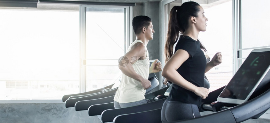 在健身俱乐部参加运动和健康概念赛跑时一对夫妇的班纳正在锻炼运动人们合身力量图片