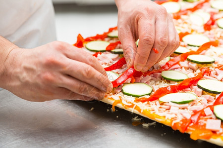 厨师准备一份美味的披萨和蔬菜男技能面包店图片