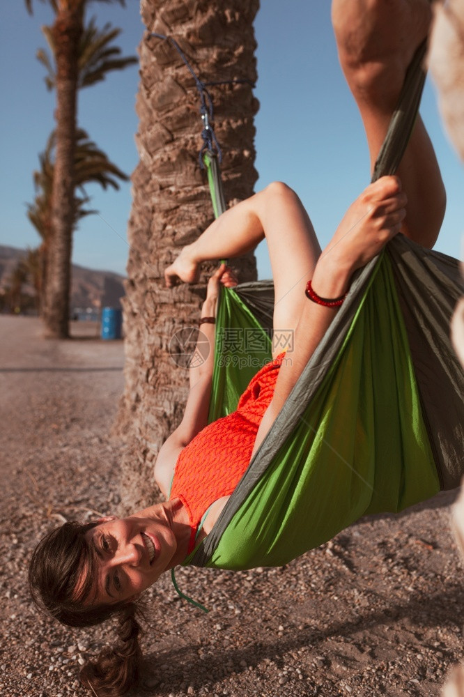 假期女人躺在海边棕榈树之间的吊床上积极热带图片