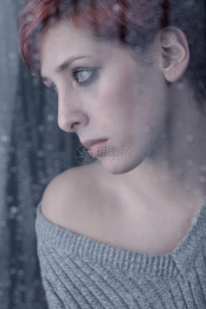 在下雨日美丽的悲伤女士在窗后等待着雨天独自的郁闷伤心图片