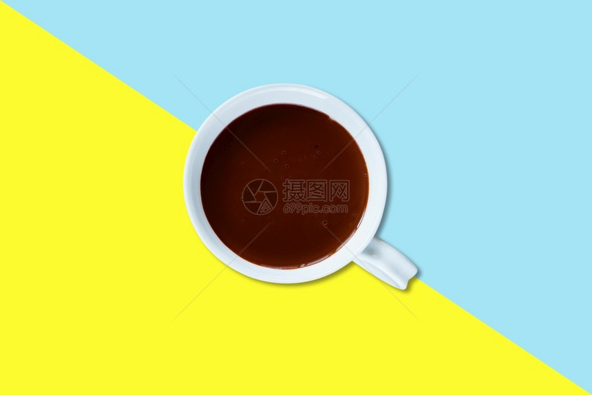 白陶瓷杯上热巧克力牛奶以彩色背景隔离粉末破碎的咖啡因图片