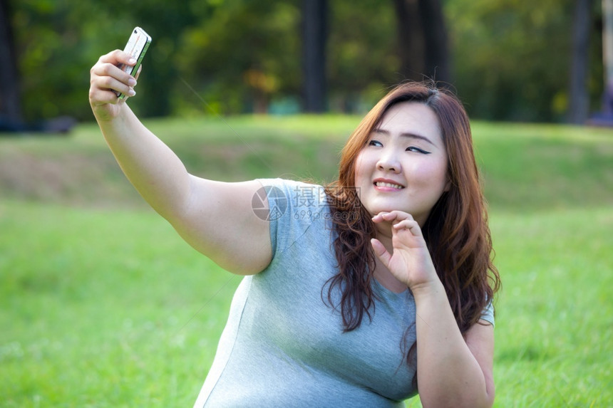 美丽电话户外漂亮的胖女人在公园玩旅行自拍图片