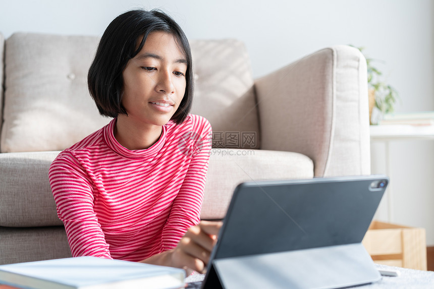 技术笔记本电脑亚裔女孩在白天早上坐客厅亚洲儿童观看和电脑教育距离上学习时在平板电脑上通过互联网进行在线学习家概念校对Portno图片
