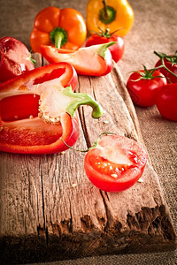 食物切割厨房鲜有机西红番茄和辣椒在布桌的木剪板上用古老风格的图象背景图片