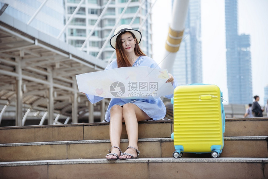 带有旅行手提箱的女游客旅度假夏日梦中旅行李箱的亚洲旅游目地拥有在现代城市旅行和生活方式概念中坐着看旅程行的游客为了保持女士图片