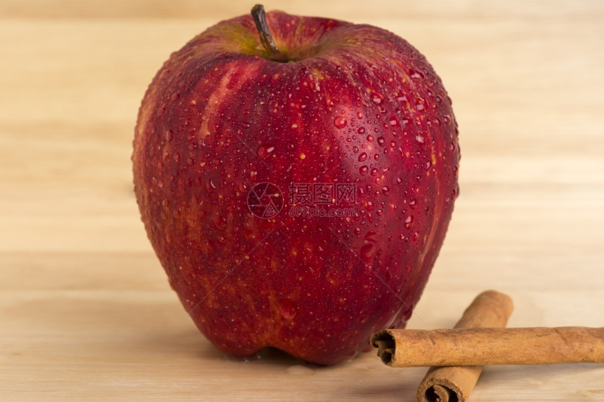 棍子木本底新成熟的红苹果和肉桂树枝新鲜成熟的红苹果和木本底烧熟的肉南椰子棒桌落下图片
