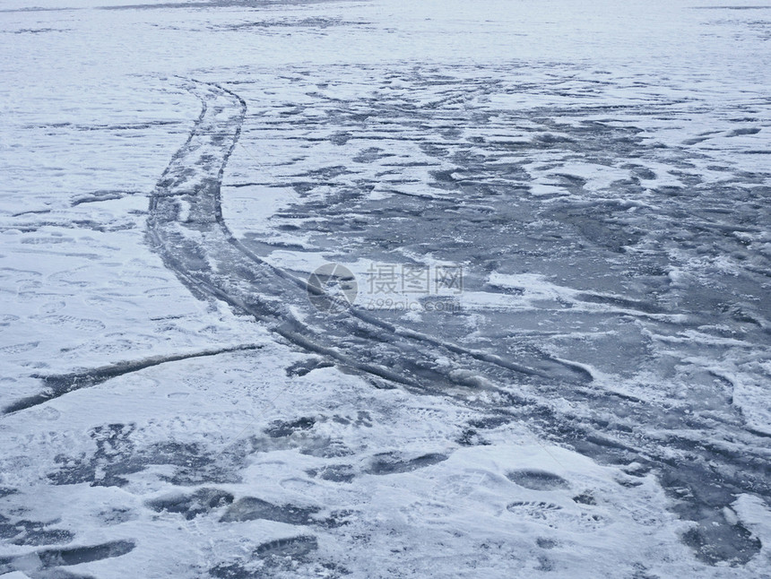 追踪雪冬季冻池塘表面有各种机械和人文印刷品北极图片