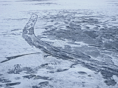 冰疙瘩追踪雪冬季冻池塘表面有各种机械和人文印刷品北极背景