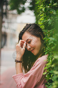 倾斜站在墙上遮着绿叶的妇女站立模型夏天图片