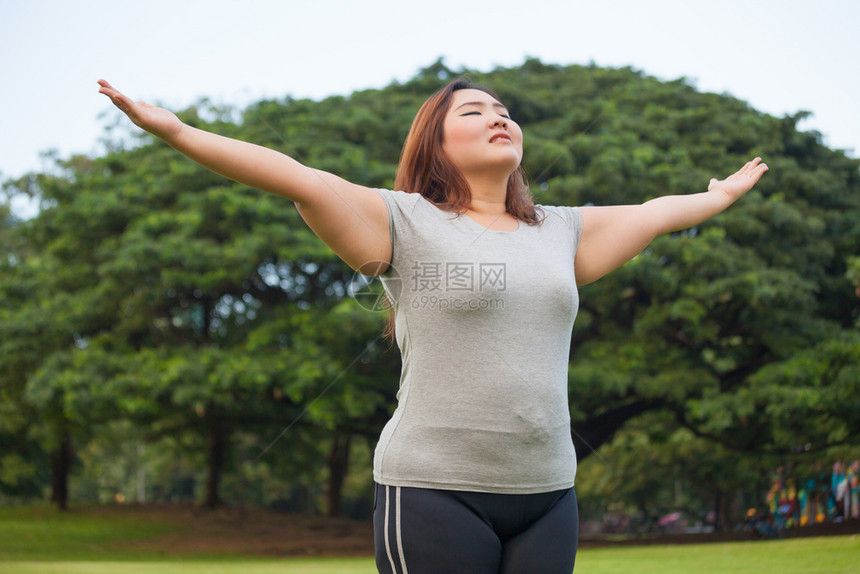 草积极的加快乐肥胖亚洲女人在公园外露面图片