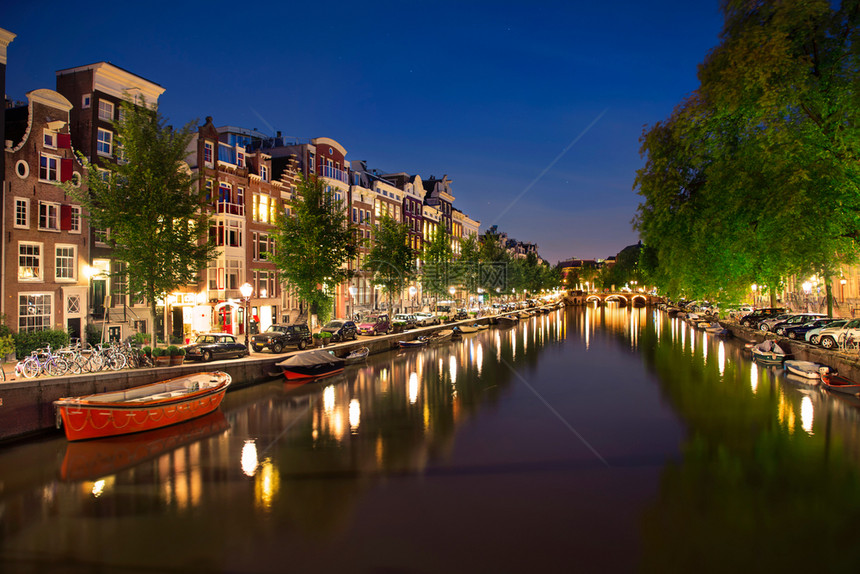 欧洲的街道荷兰阿姆斯特丹运河Singel典型的Dutch房屋和家用船晚上配有美丽的水反光镜荷兰图片