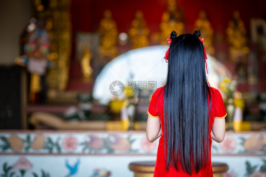 旗袍人们身着红色传统青山装饰的可爱亚洲年轻女子在泰国中华神庙为新年节举行布达雕像祷告仪式漂亮的图片