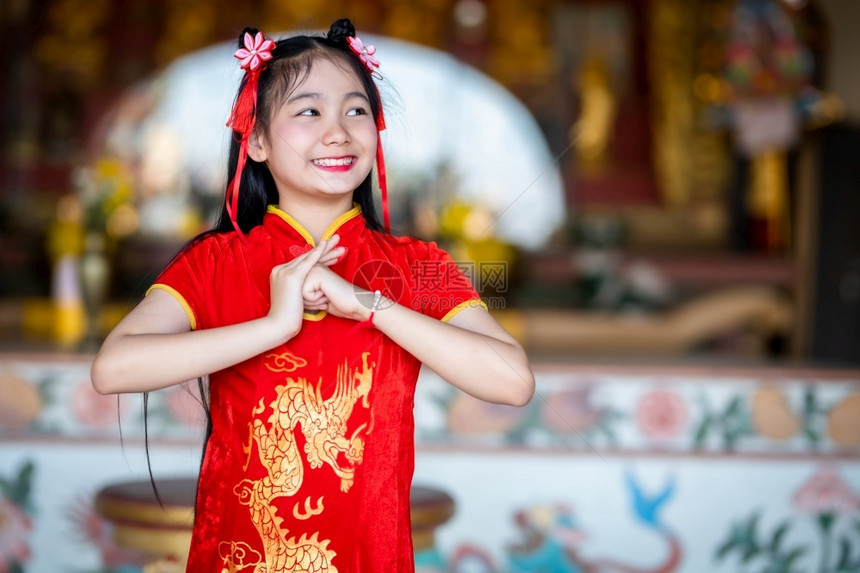 站立身着红色传统青山装饰的可爱亚洲年轻女子在泰国中华神庙为新年节举行布达雕像祷告仪式庆典手图片