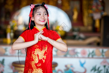 站立身着红色传统青山装饰的可爱亚洲年轻女子在泰国中华神庙为新年节举行布达雕像祷告仪式庆典手图片
