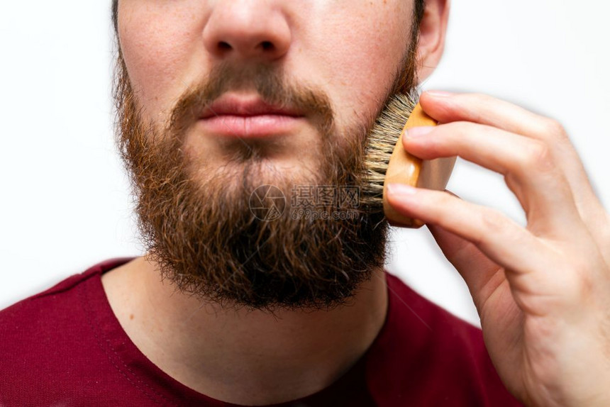 英俊男子在白色背景上刷胡须的特写镜头英俊男子在白色背景上刷胡子的特写镜头他手潮人图片