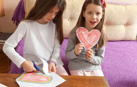 创造力小女孩正在为母亲日或父情人节生画红和多彩的心胸草图男生图片