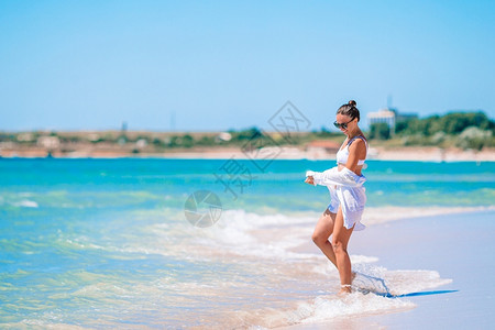 晴天热带海滩上白色沙的年轻美女天堂保持图片