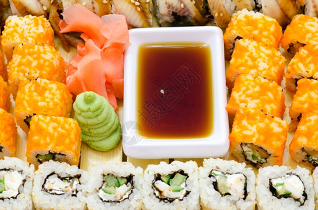 有许多寿司卷配有黄酱姜汁和油鱼子送达切片图片