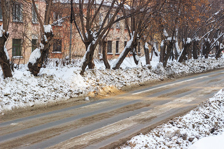 乱白色的西伯利亚市街头的肮脏雪沙尘和抗冰冷状态的试剂煤烟图片