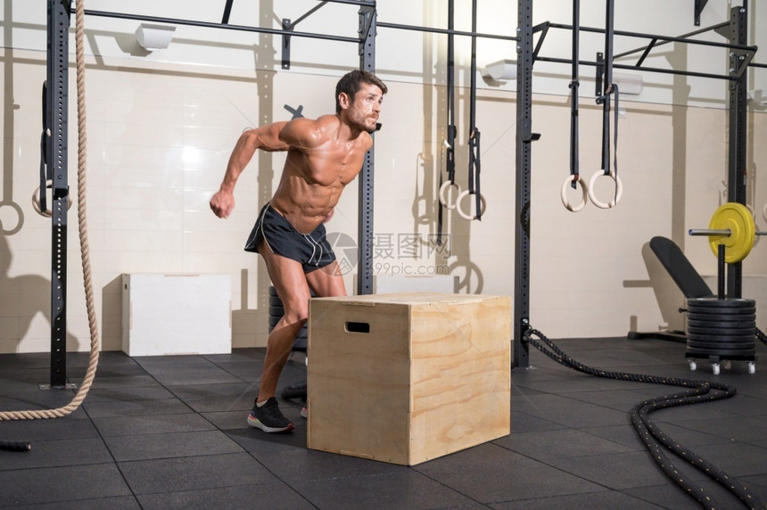 白种人木制的肌肉男运动员在现代健身俱乐部练习跳木箱功能训练高质量照片肌肉男运动员在现代健身俱乐部练习木箱跳功能训练激烈的图片