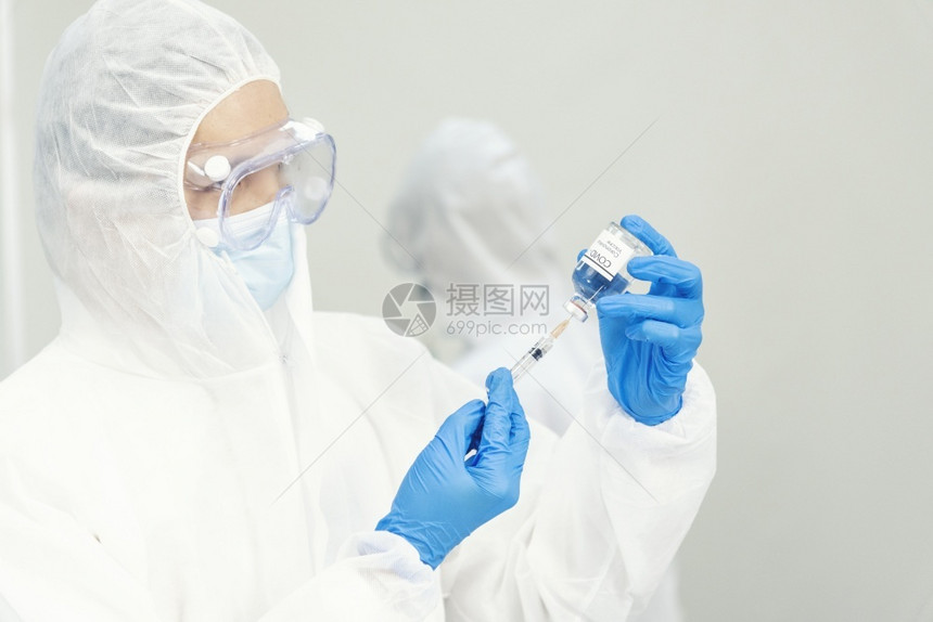手拿注射器注射疫苗的医生图片
