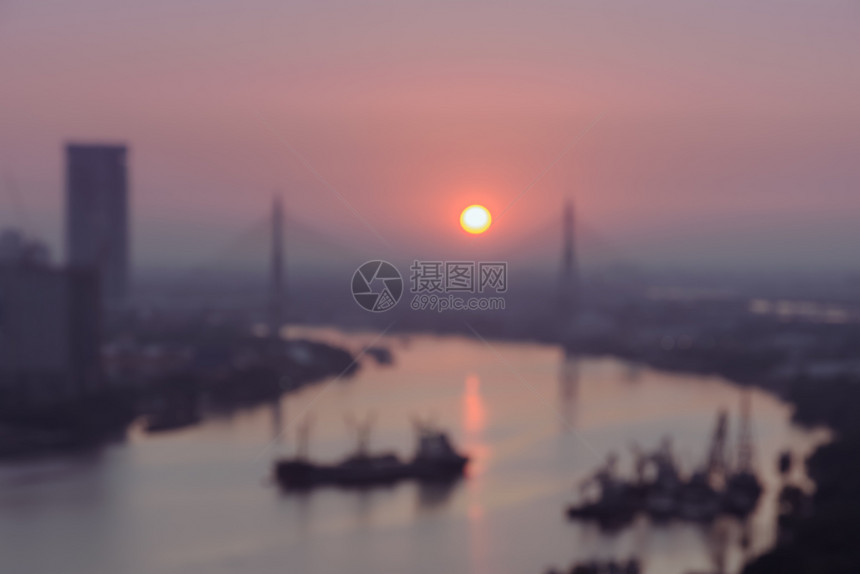 圆圈在泰国曼谷电缆桥上的金色温暖日出上河边城市天际的模糊空中观察反射超过图片