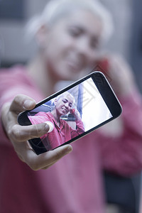 显示手机自拍的女专注于手机成人类空白的图片