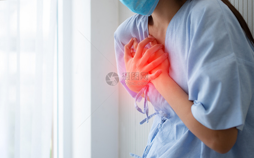 人们因心脏病发症状而戴面罩和手握胸前的女病人年轻心脏学图片