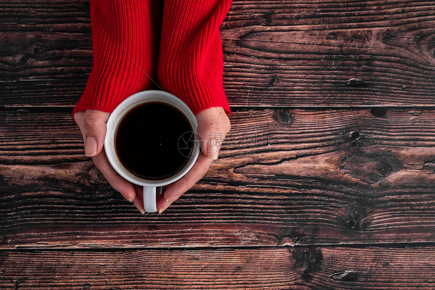 穿红色毛衣女性手持咖啡杯图片
