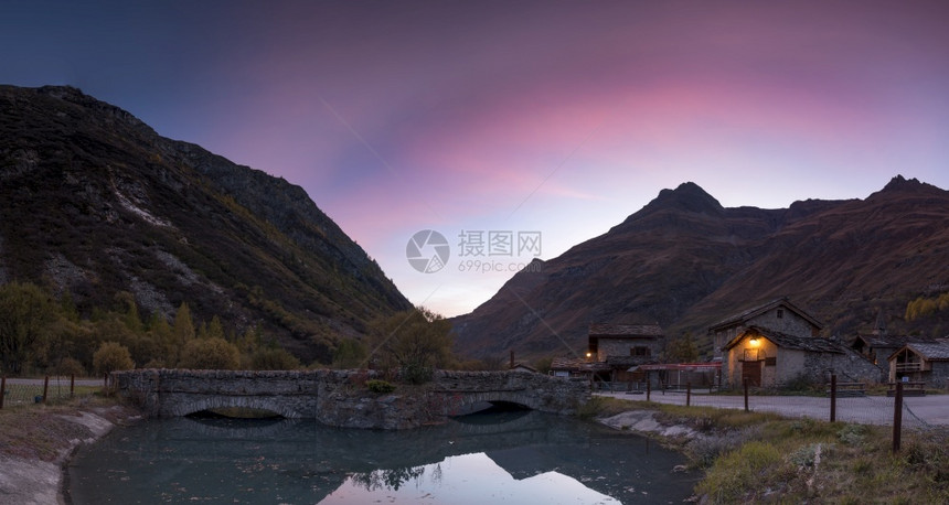 黎明步行游客山上的日落在阿尔卑斯山的池塘中映射图片