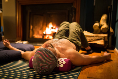 年轻的单身男子在壁炉旁放松室内单身男子在壁炉旁放松室内房间美丽的图片